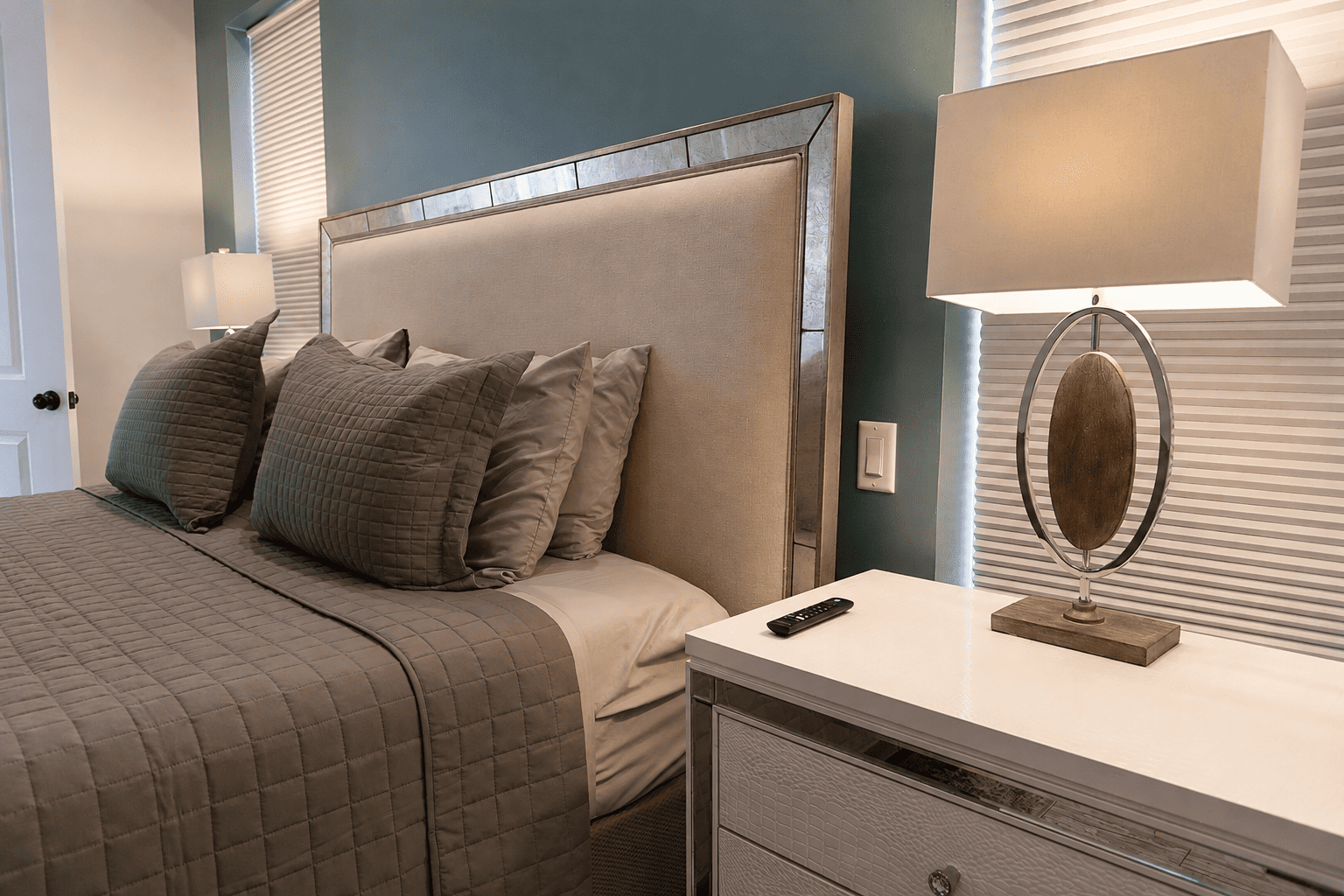 Garden Patio Bridal Suite — mirrored headboard, teal accent wall, and grey quilted bedding