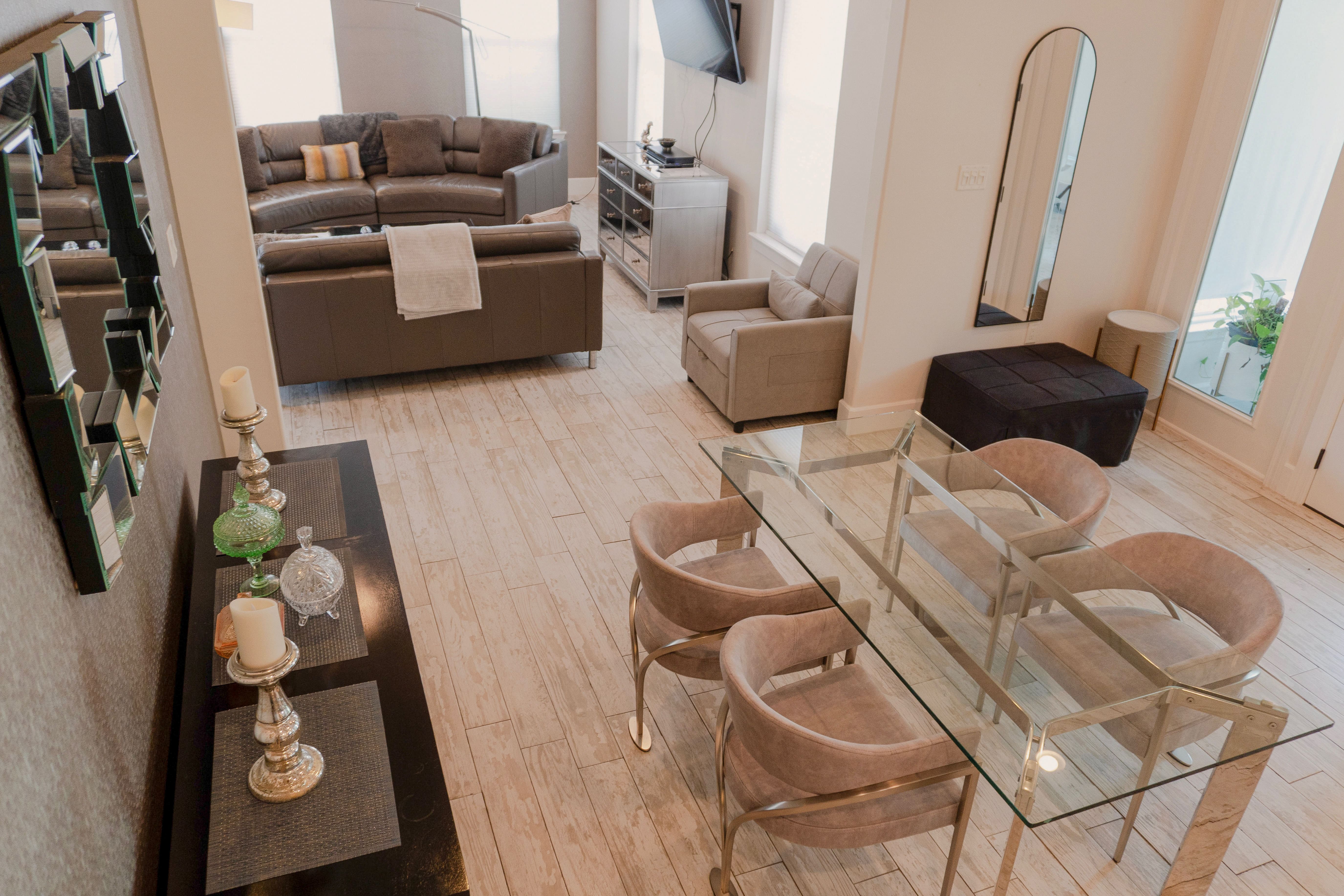 Garden Patio Bridal Suite — dining table, living area with grey sofas, and mirrored media console