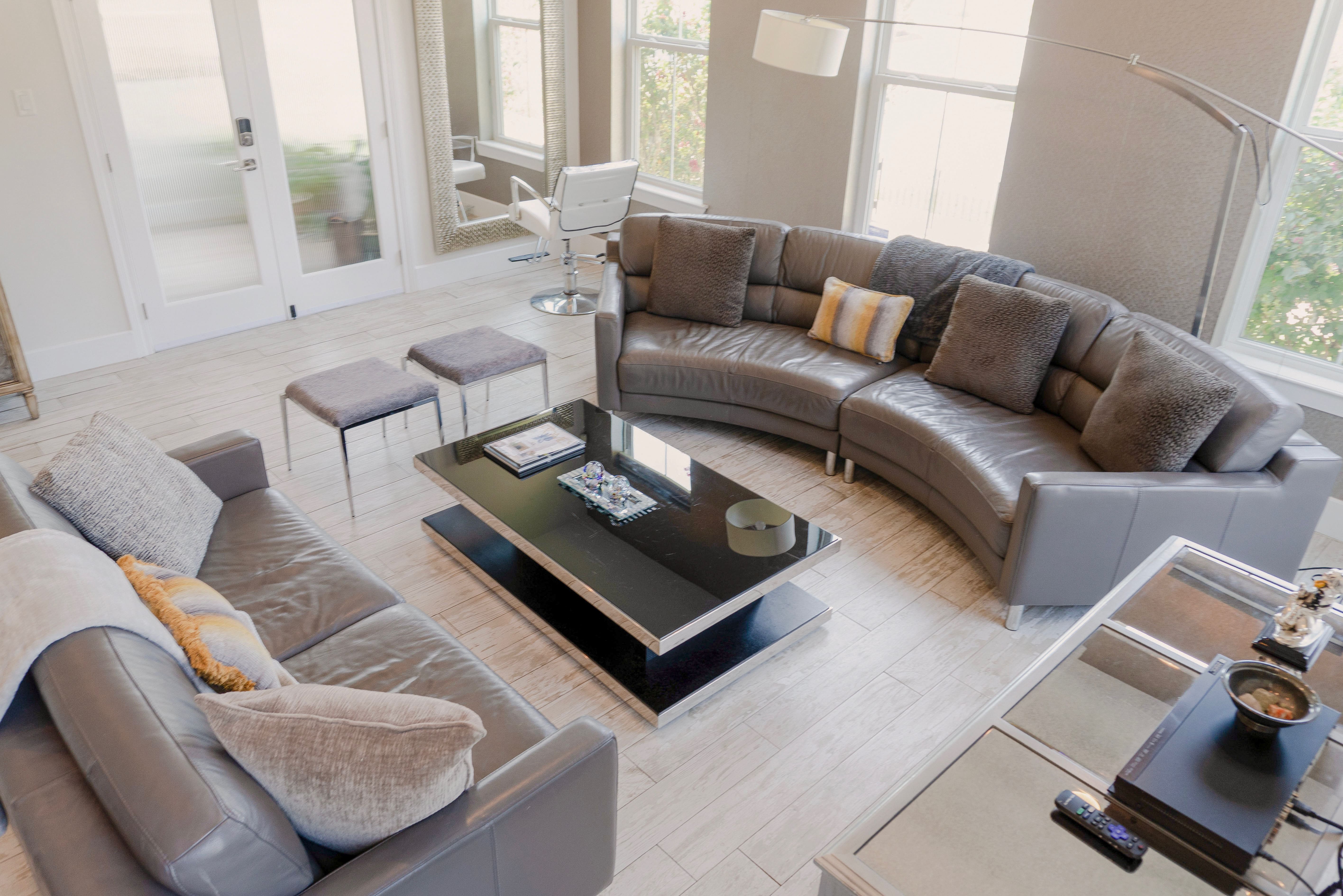 Garden Patio Bridal Suite — curved grey sectional, arc floor lamp, and frosted glass patio doors
