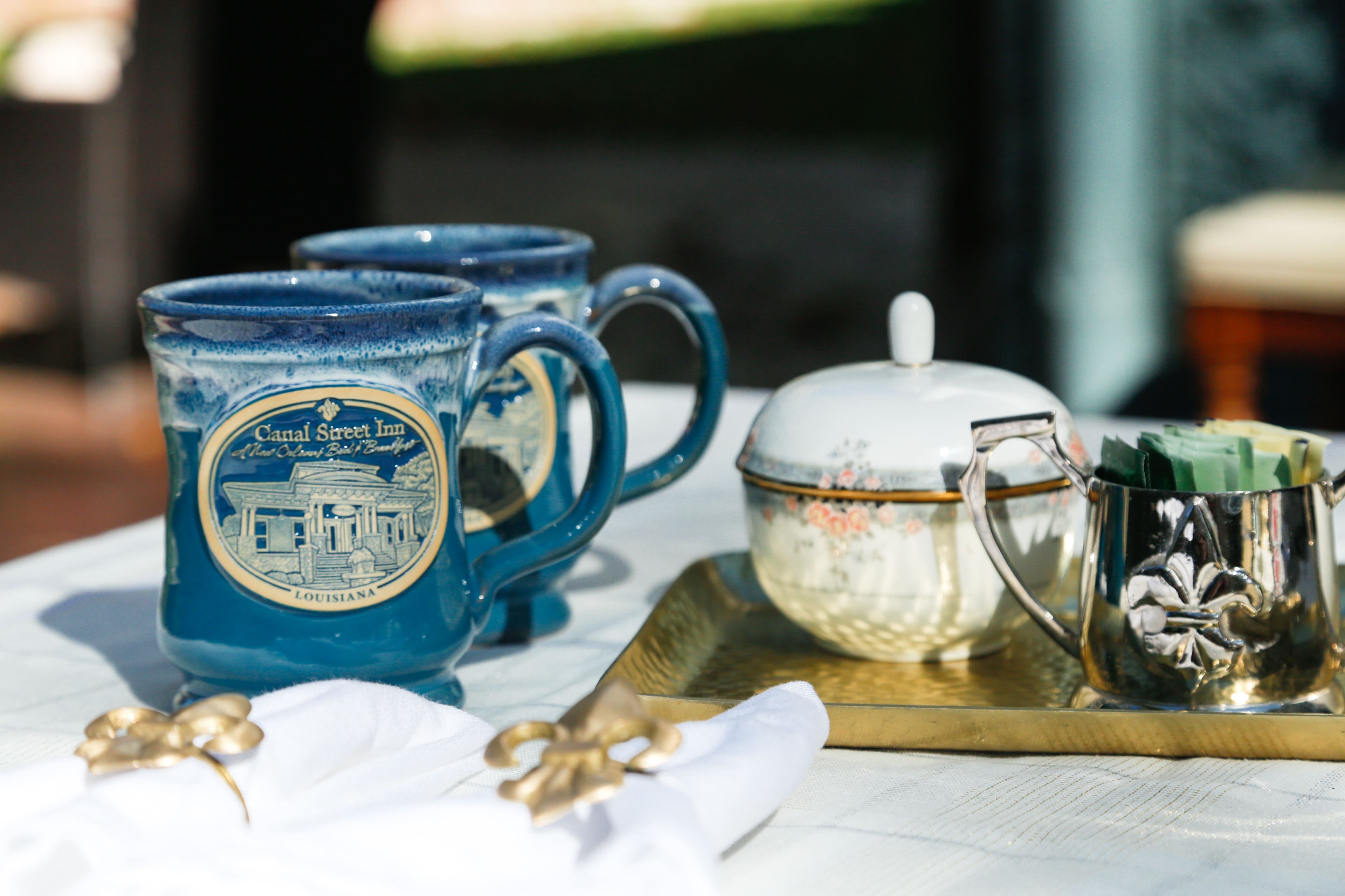 Canal Street Inn branded mugs with sugar bowl and creamer on the formal dining room table