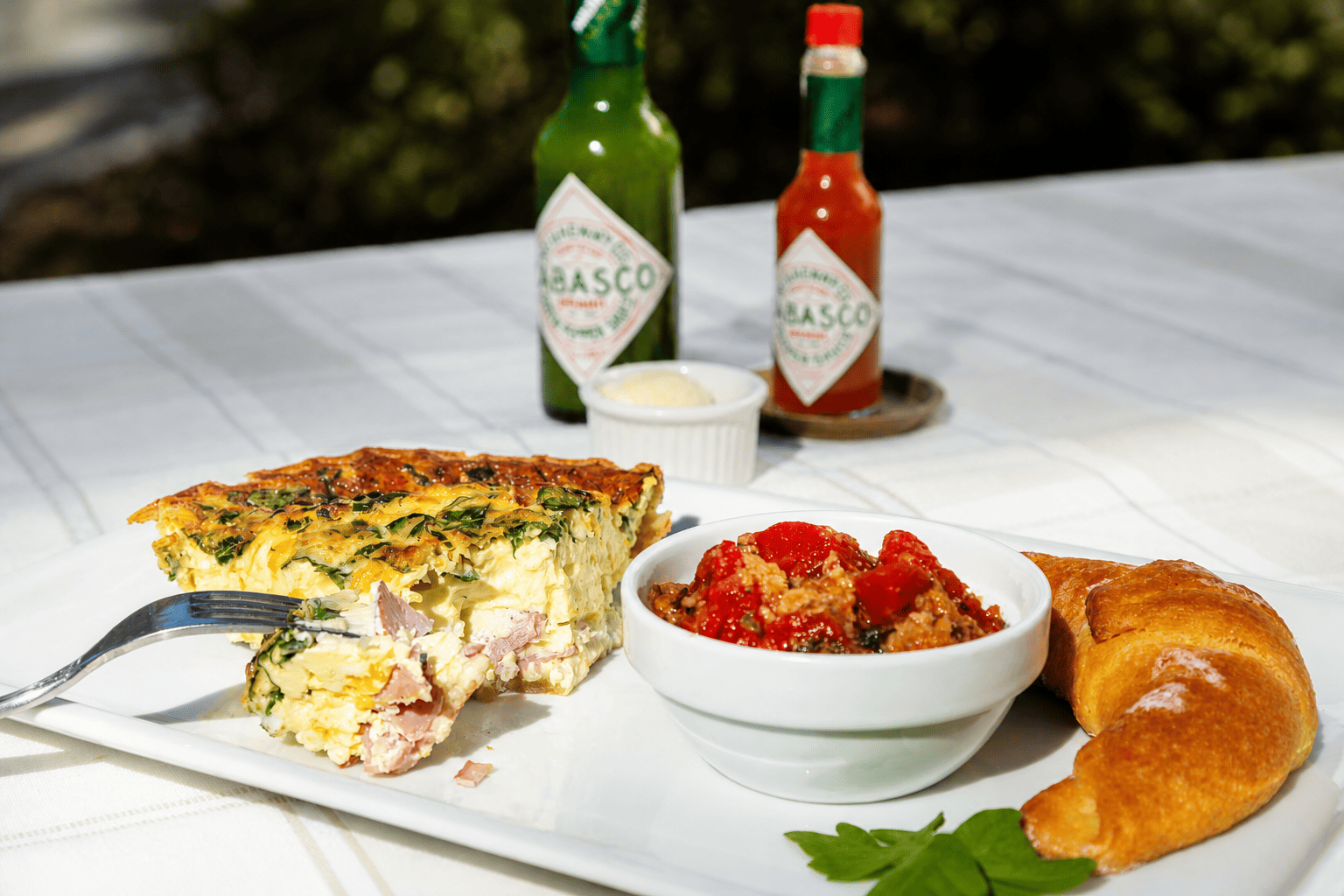 Southern breakfast plate with quiche, croissant, and fresh garnish served in the formal dining room