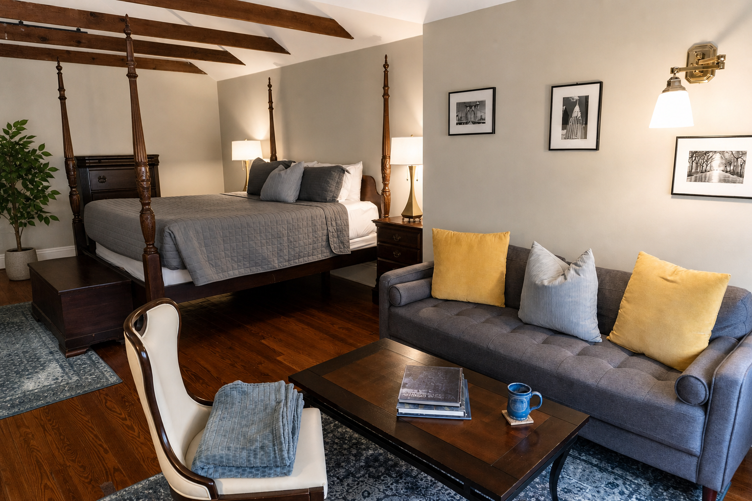The Canal Street Room — four-poster king bed, grey tufted sofa, and exposed wood beams