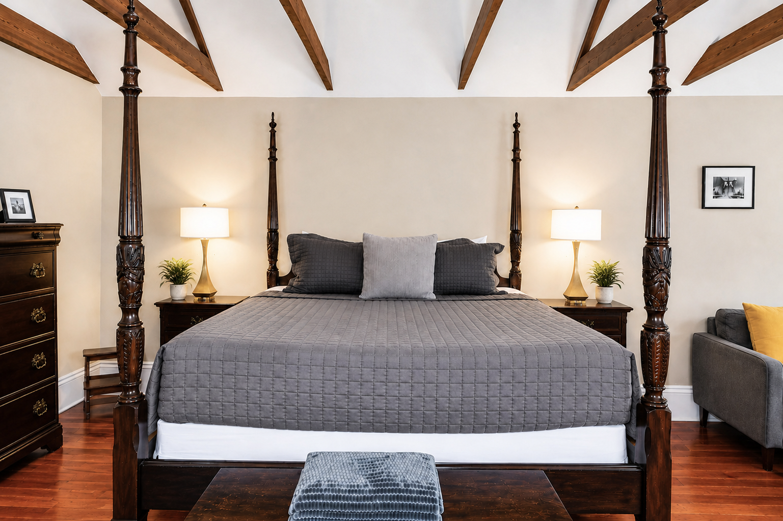 The Canal Street Room — four-poster king bed with gold lamps and hardwood floors