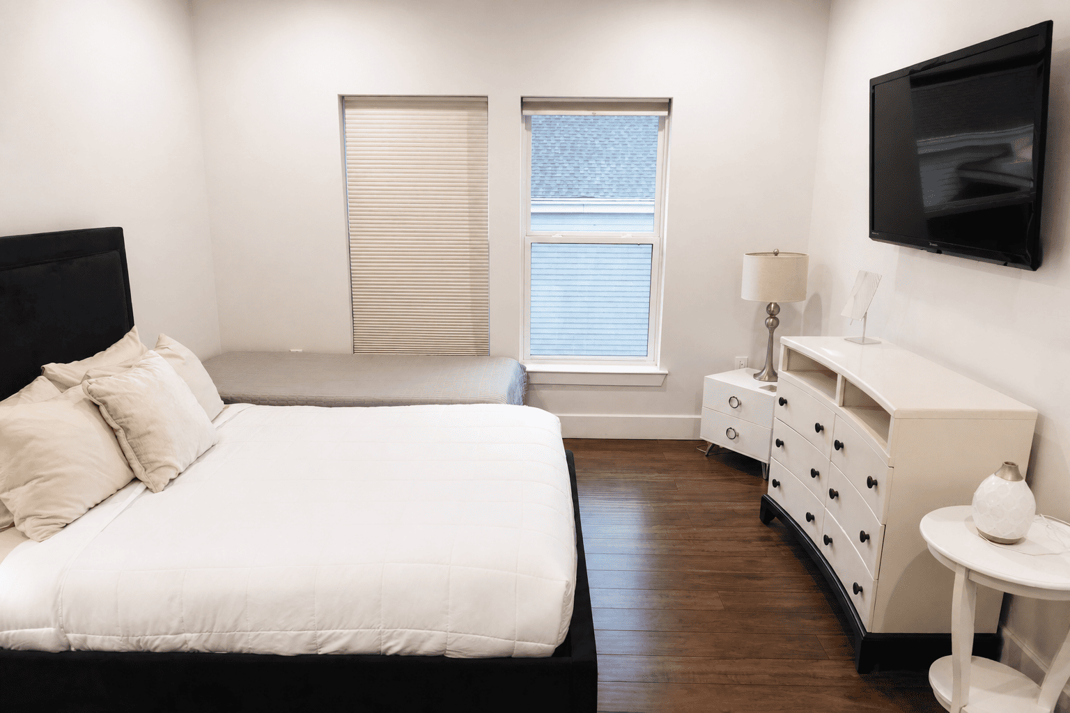 Second Floor Garden View Apartment — dining table, leather armchairs, kitchenette, and garden-facing windows