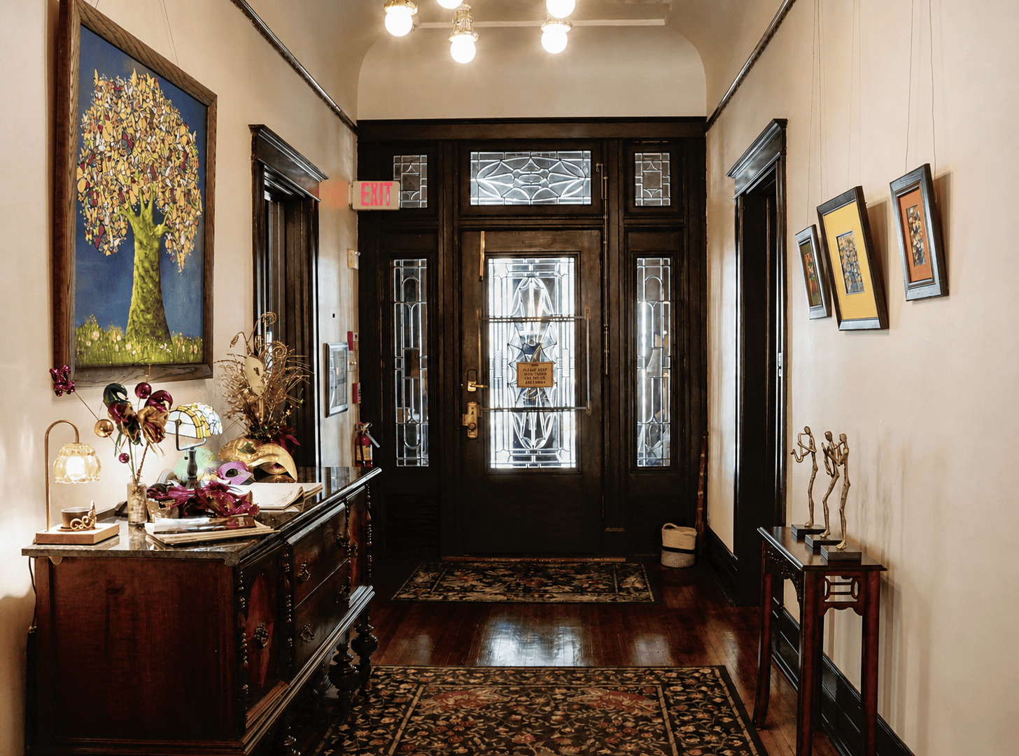 Canal Street Inn foyer with leaded-glass front door, antique sideboard, and vaulted ceiling