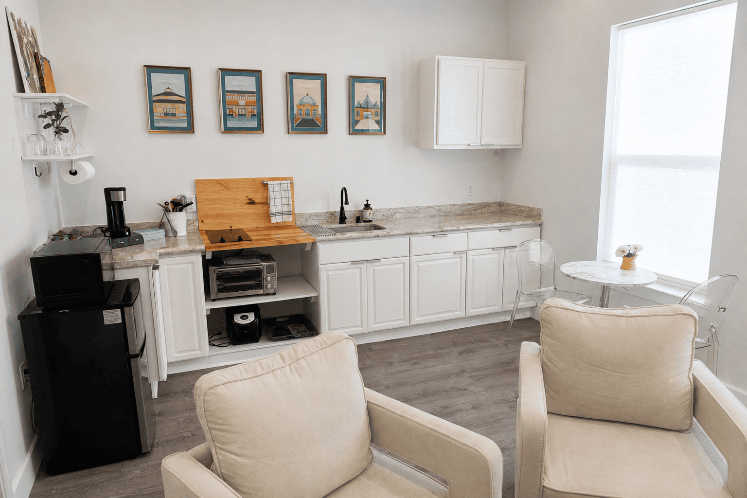 Petite Garden Suite — kitchenette with marble counter, cooktop, dining table, and ghost chairs