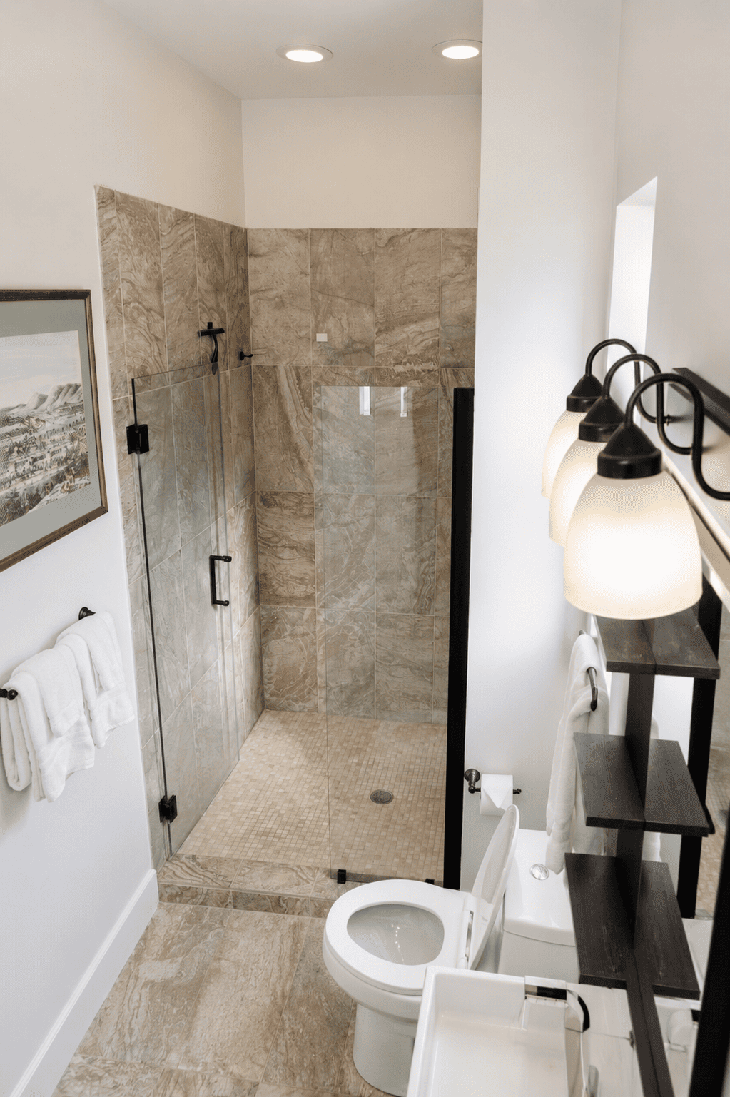 Petite Garden Suite — bathroom with walk-in glass shower, marble tile, and matte black fixtures